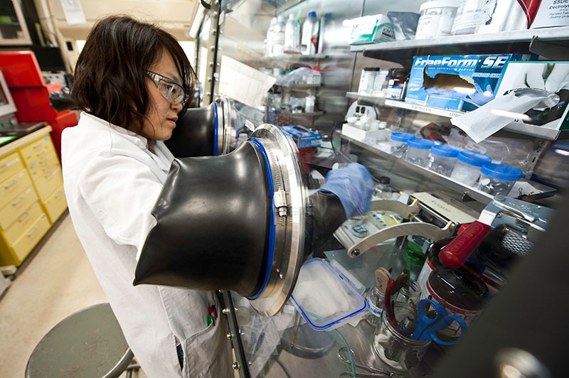 NREL Scientist Chunmei Ban assembles a lithium-ion battery in the materials lab at the Solar Energy Research Facility at NREL. Photo by Dennis Schroeder, NREL